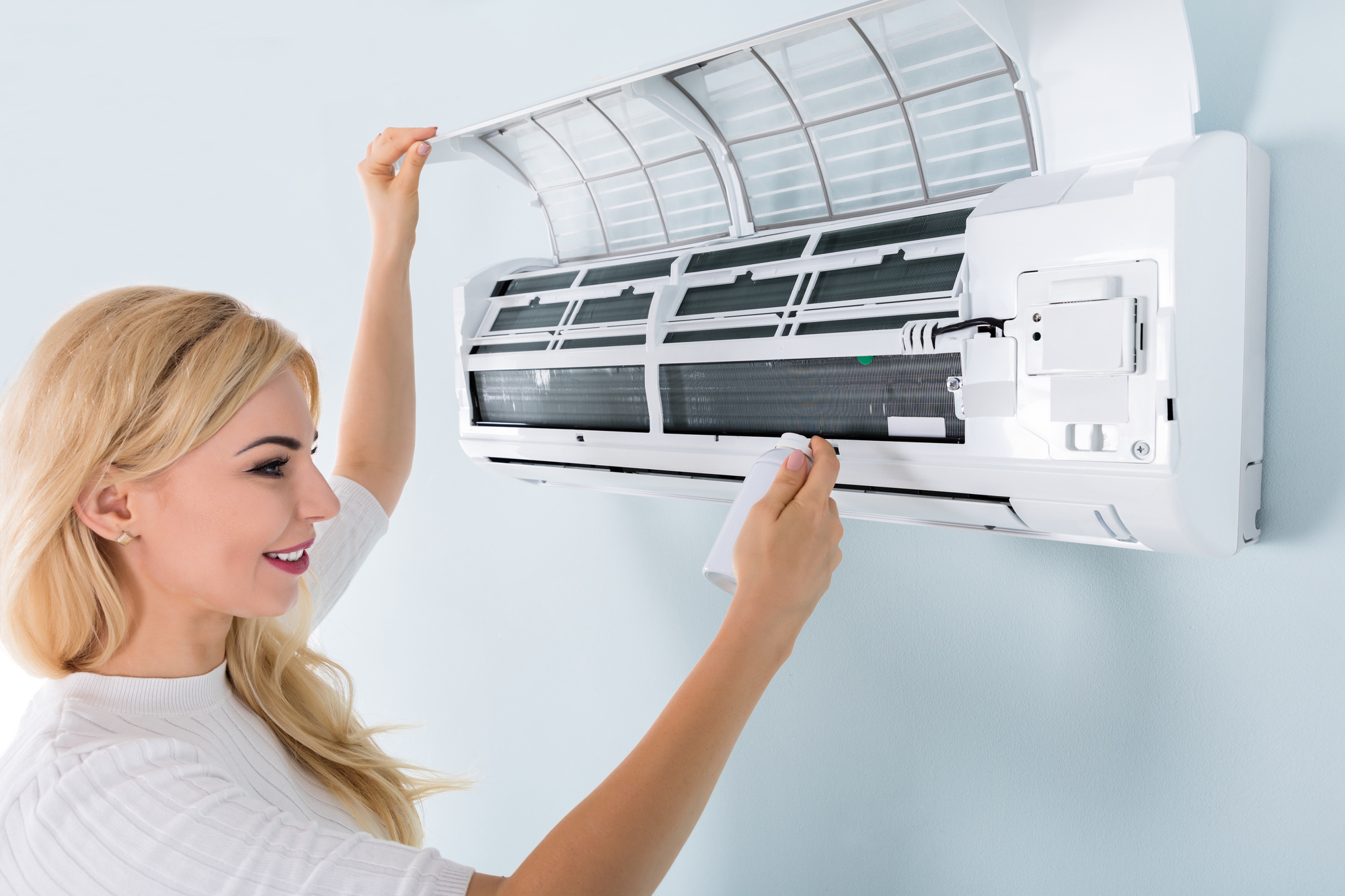 Woman Cleaning Air Conditioner